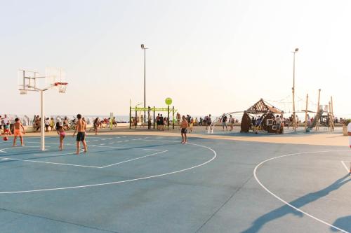 a group of people playing basketball on a basketball court at Graça Apartment in Póvoa de Varzim