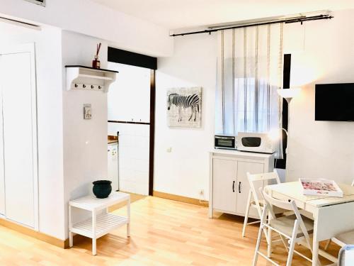 ein Wohnzimmer mit weißen Möbeln sowie einem Tisch und Stühlen in der Unterkunft Resitur Luxury Apartment 114 in Sevilla