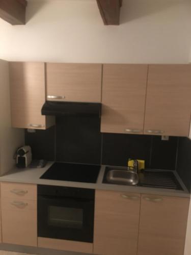 a kitchen with wooden cabinets and a stove top oven at Studio Grand Rue in Colmar