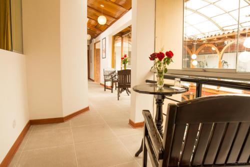 ein Esszimmer mit einem Tisch mit Blumen darauf in der Unterkunft Hotel San Pedro Plaza in Cusco