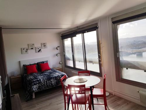 Zimmer mit einem Tisch, einem Bett und einem Fenster in der Unterkunft Hirondelle de Rouen in Rouen