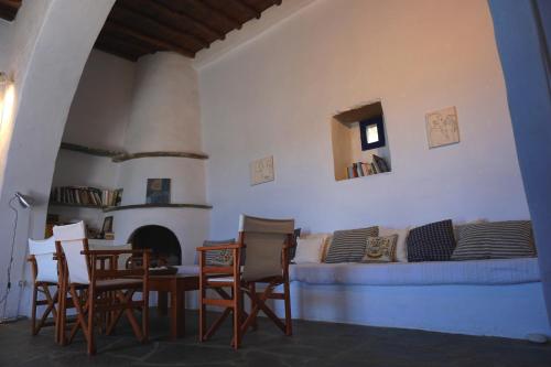 een woonkamer met een bank en een tafel en stoelen bij Beautiful house in Tinos Island in Triandáros