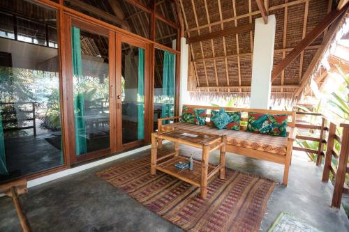 sala de estar con banco y mesa en Ferra Resort Siargao, en General Luna