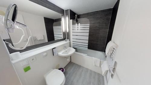 een badkamer met een wastafel, een toilet en een spiegel bij Kyriad Meaux Sud Nanteuil Les Meaux in Nanteuil-lès-Meaux