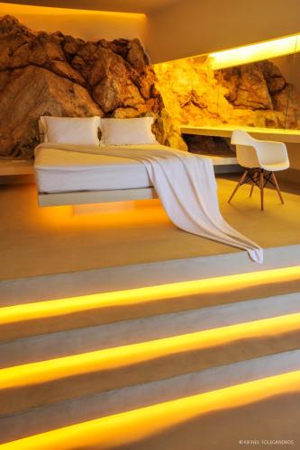 a bedroom with a bed with yellow lights at Kifines Suites in Chora Folegandros