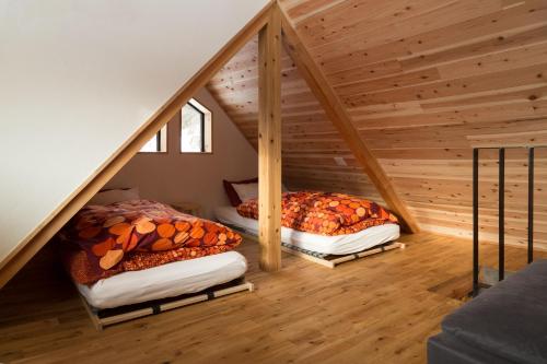 two beds in the attic of a house at Harvest House Nozawa in Nozawa Onsen