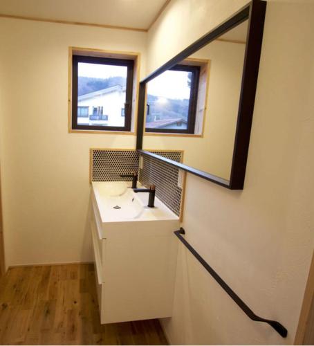 a bathroom with a sink and a mirror at Harvest House Nozawa in Nozawa Onsen