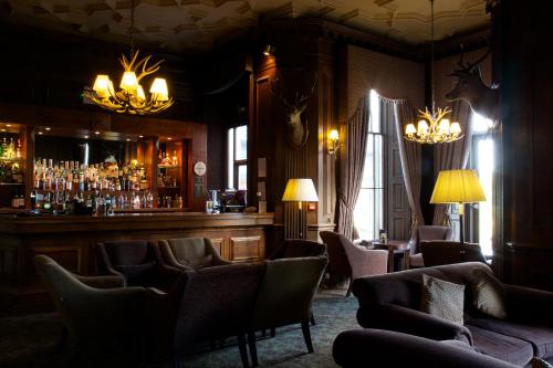 a bar with a lot of chairs and a bar counter at Stonefield Castle Hotel ‘A Bespoke Hotel’ in Stonefield