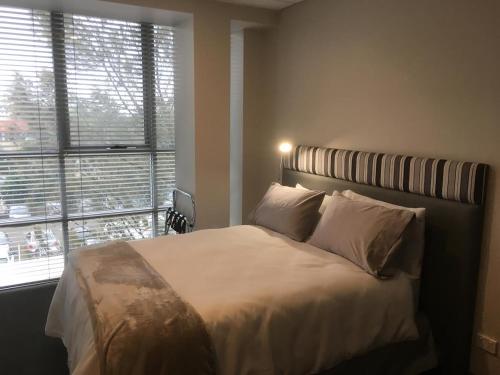 1 dormitorio con cama y ventana grande en MEDISTAY en Sídney