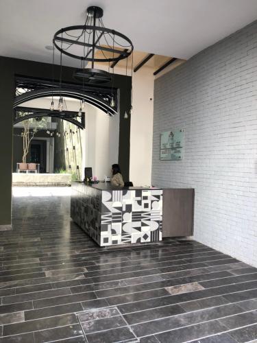 a lobby with a counter with a person sitting on it at Hotel Isabel in Puebla