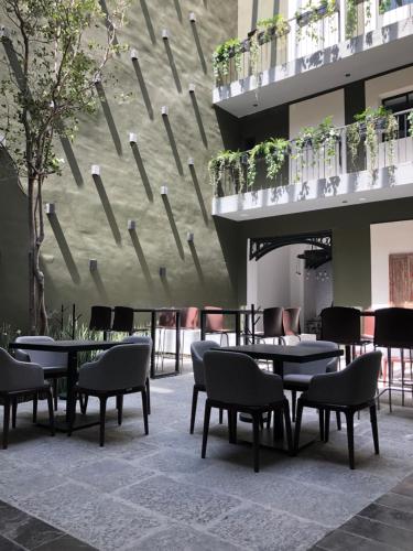 a courtyard with tables and chairs and a building at Hotel Isabel in Puebla
