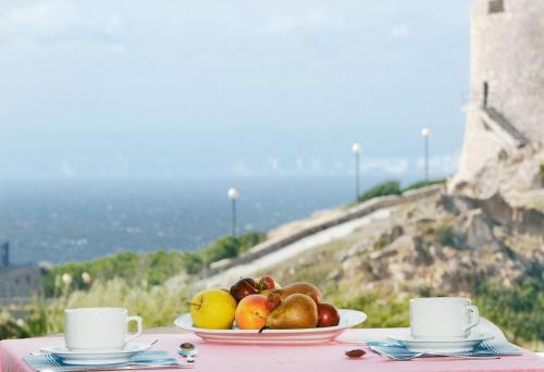a table topped with a bowl of fruit and a glass of water at Hotel Da Cecco in Santa Teresa Gallura