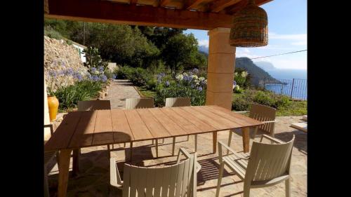 a wooden table and chairs on a patio at C'an Co Banyalbufar in Banyalbufar