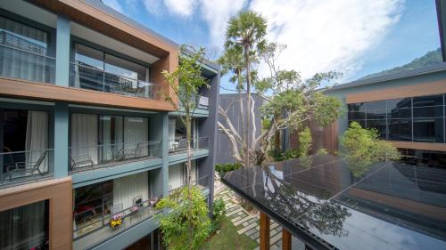 an external view of a building with a balcony at The Nature Phuket - SHA Extra Plus in Patong Beach