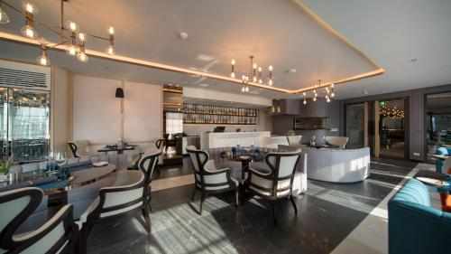 a restaurant with chairs and tables and a bar at The Nature Phuket - SHA Extra Plus in Patong Beach