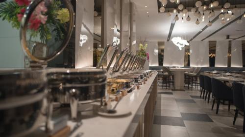 a dining room with tables and chairs and a mirror at The Nature Phuket - SHA Extra Plus in Patong Beach