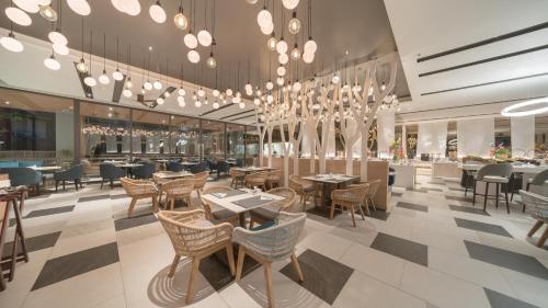 a restaurant with tables and chairs and chandeliers at The Nature Phuket - SHA Extra Plus in Patong Beach
