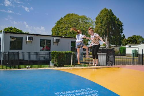 a man and a woman jumping on a skateboard over a pool at BIG4 Toowoomba Garden City Holiday Park in Toowoomba