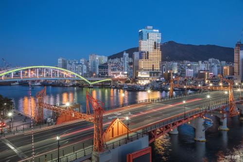 a bridge over a river with a city at night at Lavalse Hotel in Busan