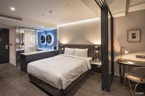 a bedroom with a large bed and a bathroom at Lavalse Hotel in Busan