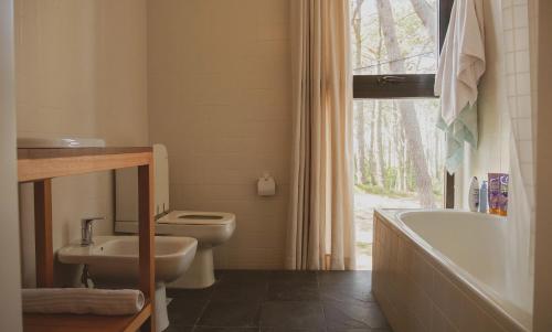 a bathroom with a tub and a toilet and a sink at La Uruguaya in Ocean Park