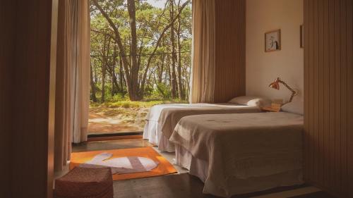 two beds in a room with a window at La Uruguaya in Ocean Park