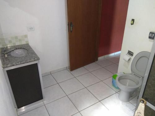 a bathroom with a toilet and a sink at Recanto dos Sonhos in Vargem