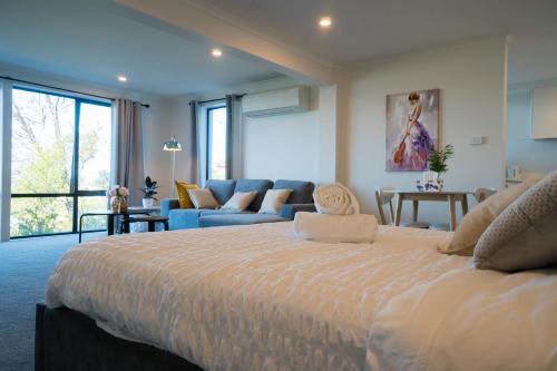 a large bedroom with a large bed and a couch at Amazing Sea Views Luxury Guest House in Hobart