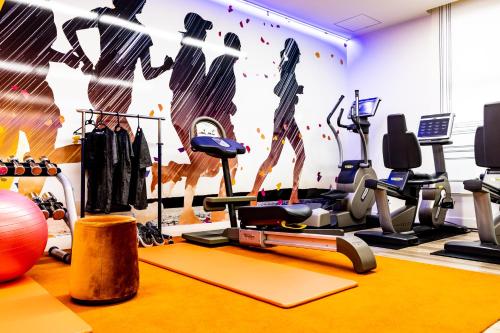 a gym with exercise equipment and a wall mural at Grand Park Hotel The Luxueux Minami Kashiwa in Kashiwa
