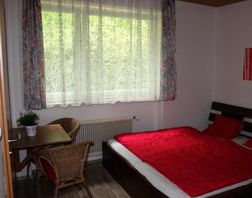 a bedroom with a bed and a table and a window at Haus Tamara in Finkenberg