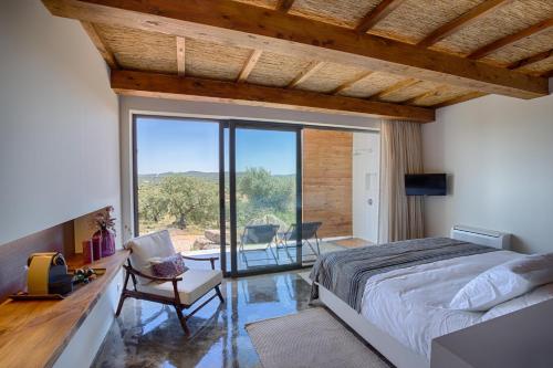 - une chambre avec un lit, une table et un balcon dans l'établissement Monte Velho Equo-Resort, à Arraiolos