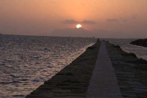 a pier stretches out into the ocean at sunset at Anita & Garibaldi in Marsala
