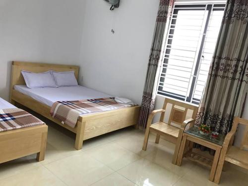 a bedroom with a bed and a chair and a window at Nhà nghỉ Mạnh Bình in Hai Phong