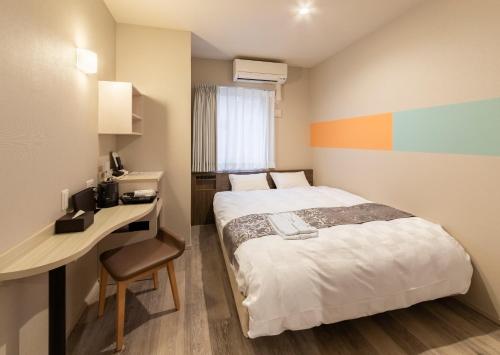 a small room with a bed and a desk at SARASA HOTEL Dotonbori in Osaka