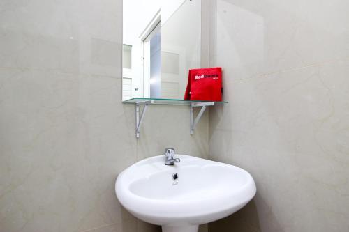 un bagno con un lavandino bianco e uno specchio di Griya Izzara Guest House Syariah a Sleman