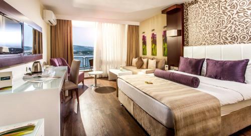 una camera d'albergo con un grande letto e un soggiorno di Tusan Beach Resort - All Inclusive a Kusadası