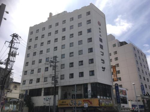 a large white building on the corner of a street at Hotel Kokusai Plaza (Kokusai-Dori) in Naha