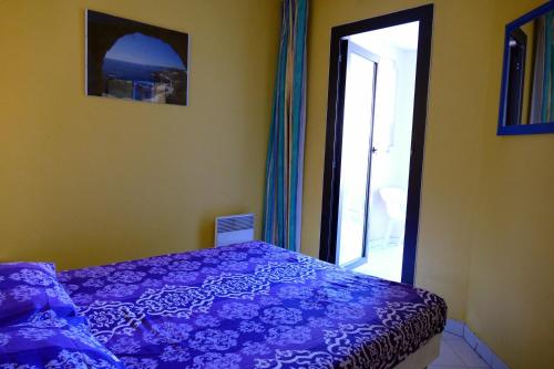 une chambre avec un lit violet et une fenêtre dans l'établissement Cannes, La Palme d'Or, à Cannes