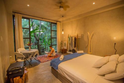 a child sitting on a rug in a bedroom with a bed at Kapievi Ecovillage in Puerto Maldonado