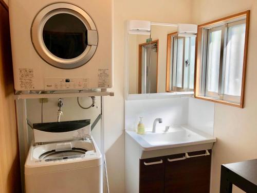 ein kleines Bad mit einem Waschbecken und einer Waschmaschine in der Unterkunft Life is a Journey in Yomitan