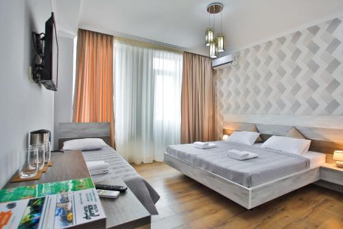 a bedroom with a bed and a desk with a table at Hotel Terrace Kutaisi in Kutaisi