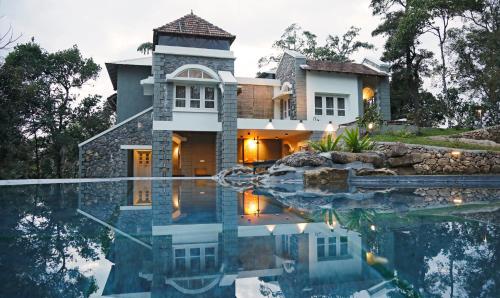 a house with a swimming pool in front of a house at SpiceTree Rajakumari in Munnar