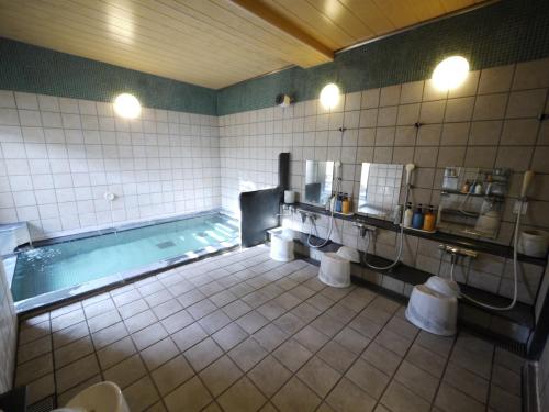 a bathroom with a swimming pool with sinks and mirrors at Hotel Route-Inn Oita Ekimae in Oita
