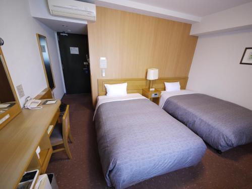 Ένα ή περισσότερα κρεβάτια σε δωμάτιο στο Hotel Route-Inn Oita Ekimae