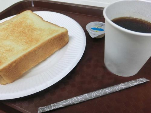 a white plate with a piece of bread and a cup of coffee at Prince Hotel Shimonoseki in Shimonoseki