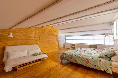 a bedroom with a bed and a couch at Casa Creu in Sant Feliu de Guixols