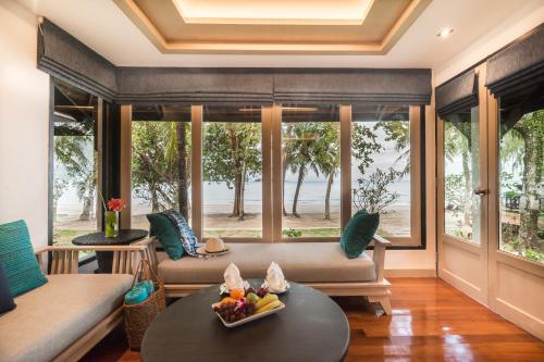ein Wohnzimmer mit einem Sofa und einem Tisch in der Unterkunft Barali Beach Resort & Spa in Ko Chang