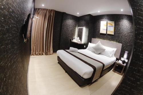 a bedroom with a bed and a large mirror at Here Hotel in Skudai