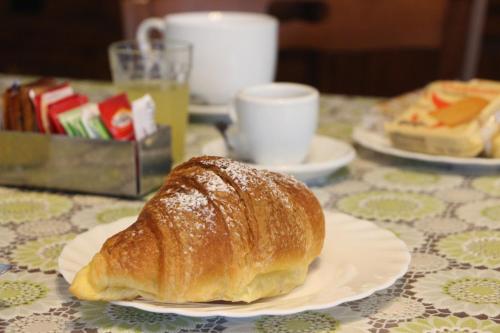 ein Croissant auf einem Teller auf einem Tisch in der Unterkunft Villa De Angelis in Sorrent