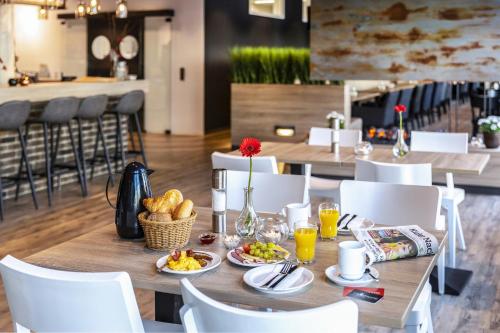 a table with plates of food on it in a restaurant at Hotel Athletik Kiel in Altenholz